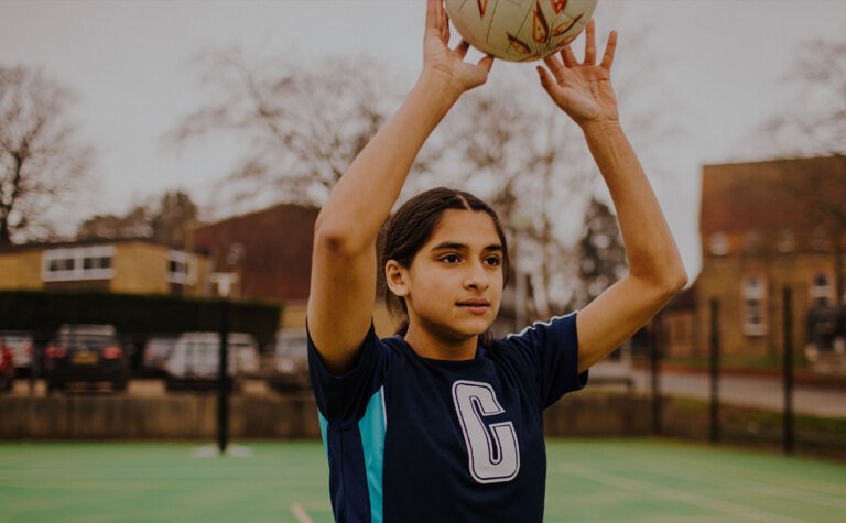 Senior school girl throwing ball in a game of netball at St Margaret's School