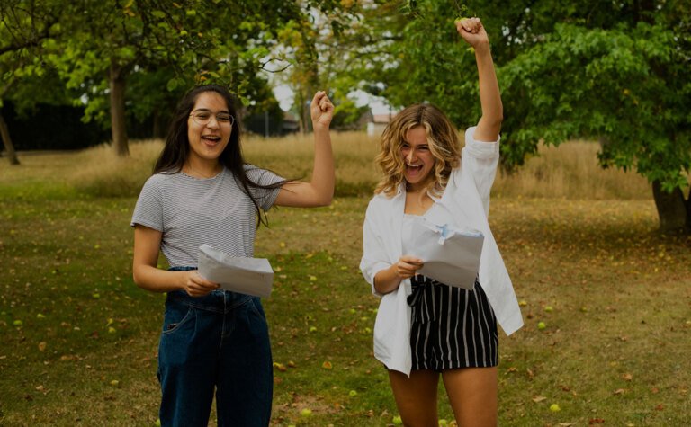 Two sixth form students celebrating their achievements on exam results day ready for University