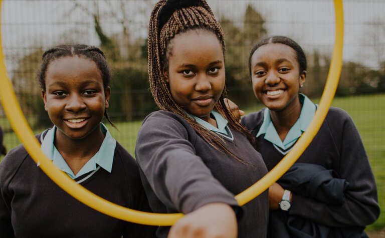 Three senior school pupils enjoying time together outside at St Margaret's School Bushey