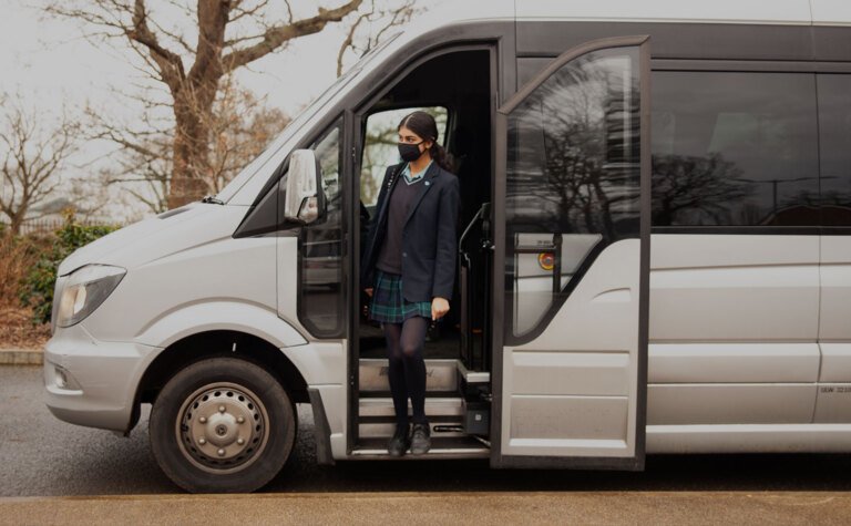St Margaret's School pupil arriving at school stepping off minibus in which they travelled to school