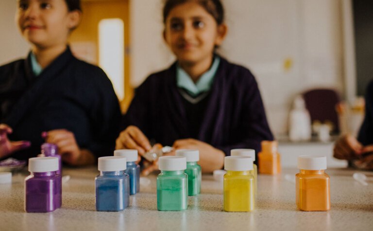 Colourful paint pots being used by upper junior school pupils in co-curricular activities at St Margaret's School