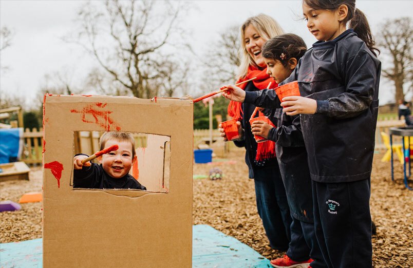 Group of nursery age children painting outside at co-educational St Margaret's School