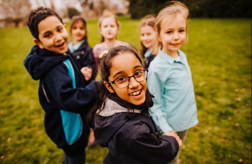 Junior school pupils playing outside at St Margaret's co-educational school in Bushey