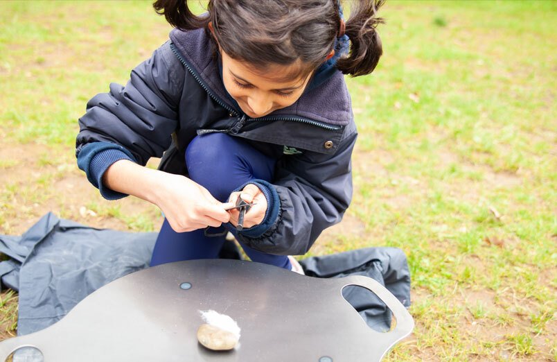 St Margarets School Junior pupil learning how to light a fire