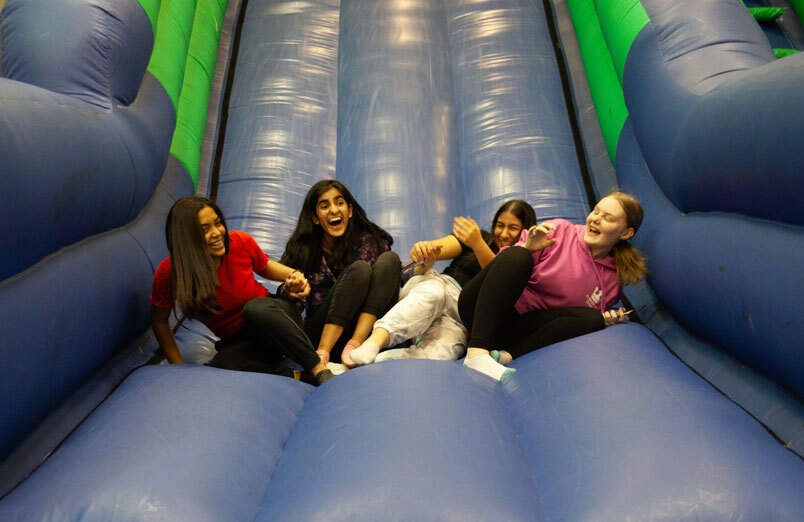 St Margaret's Sixth Form Students on bouncy castle at leaver's party