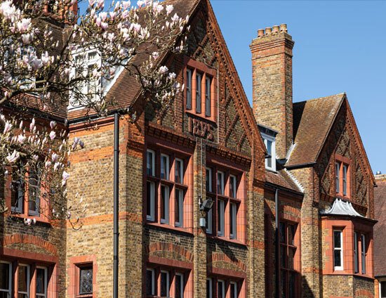 The front of the main Waterhouse School building at St Margarets School with a blossoming magnolia tree in foreground