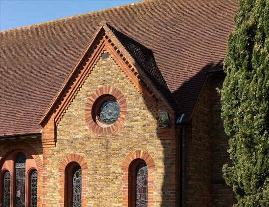 The roofline and circular stained glass window of the Waterhouse building at St Margaret's School in Bushey