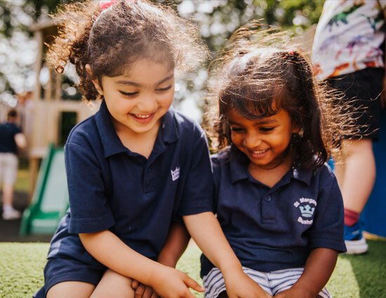 Two Nursery aged pupils playing outside in the sunshine