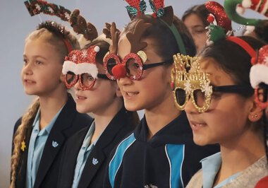 Group of St Margaret's School choir wearing Christmas glasses and headbands