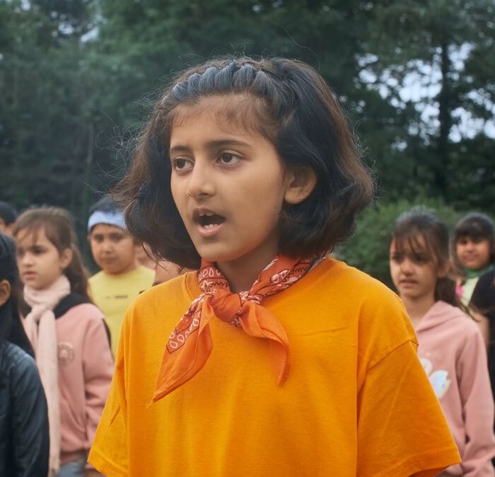 A St Margaret's Junior School pupil singing in the Believer music video