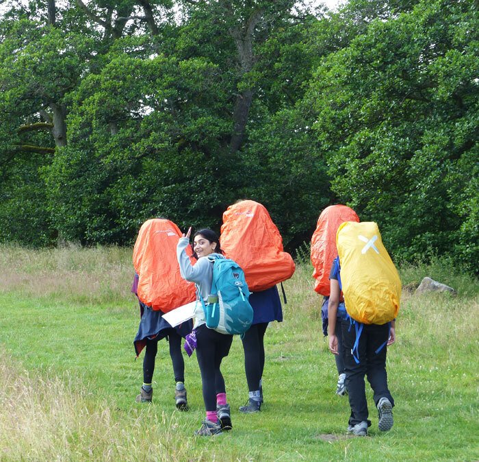 Girl waving whilst heading off with friends on Duke of Edinburgh's award expedition