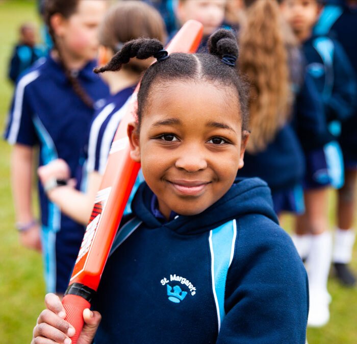 Young girl at St Margarets School playing cricket with classmates