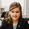 Upper junior school pupil sitting at desk in classroom at St Margaret's School Bushey